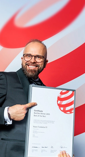 De CEO van Vasco Electronics met de Red Dot Award in zijn handen, terwijl hij de bekroonde apparaten laat zien.